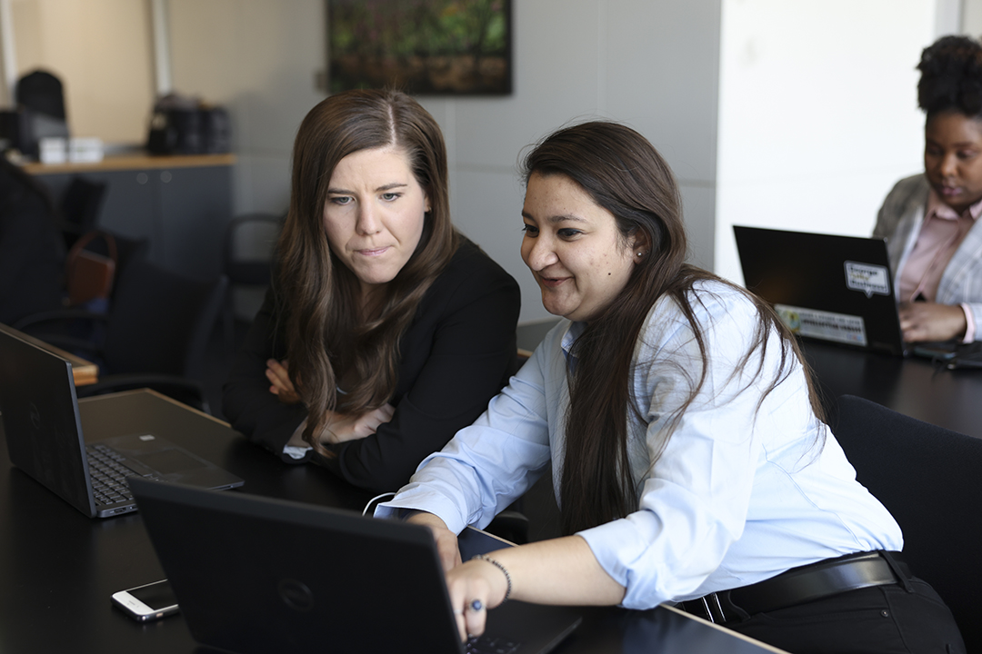 GWSB MBA students collaborate on work using a laptop