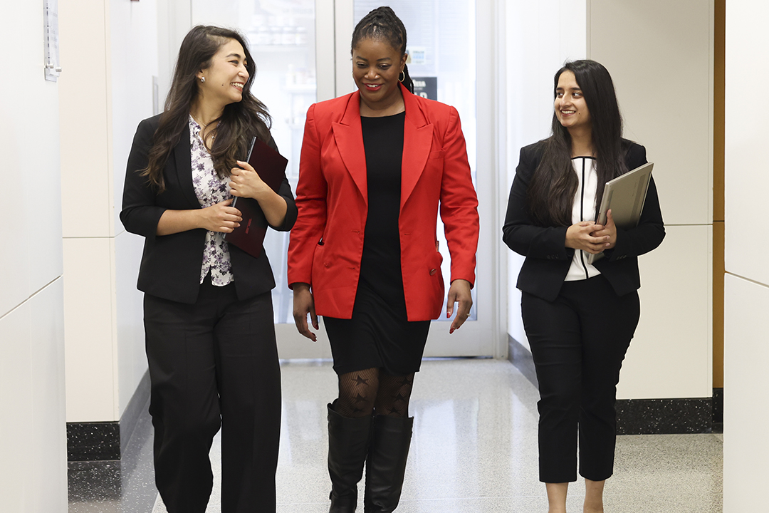 three women in the GWSB Global MBA program chat in a hallway during classes