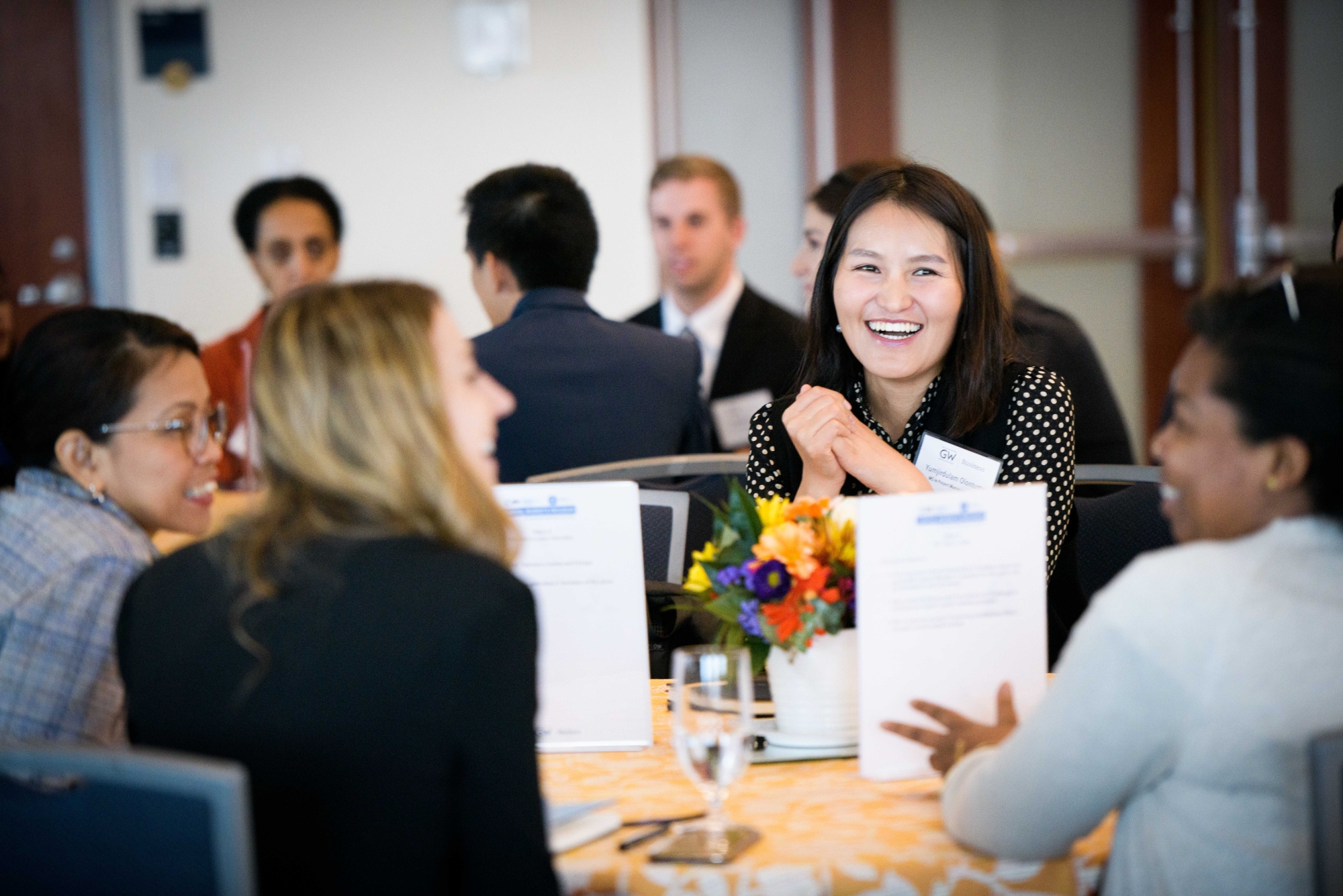 groups of smiling people seated around tables during a GWSB event