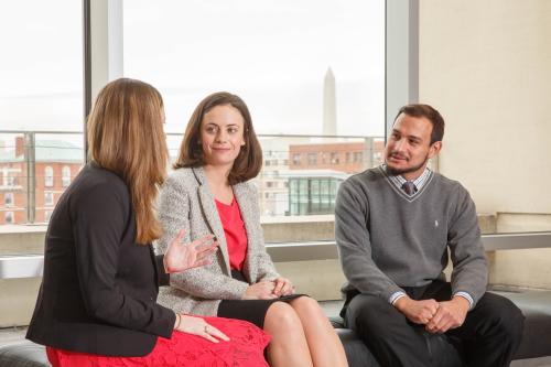 students seated indoors with Washington Monument visible through window behind them