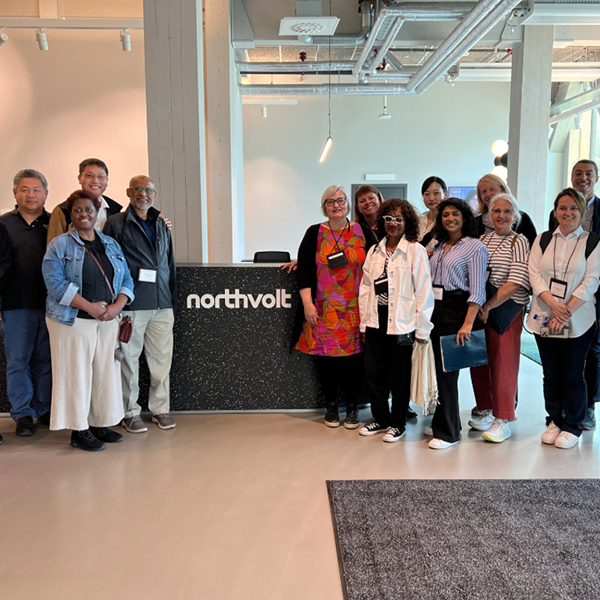 A group of people in a large office lobby in front of a desk with the text "Northvolt."