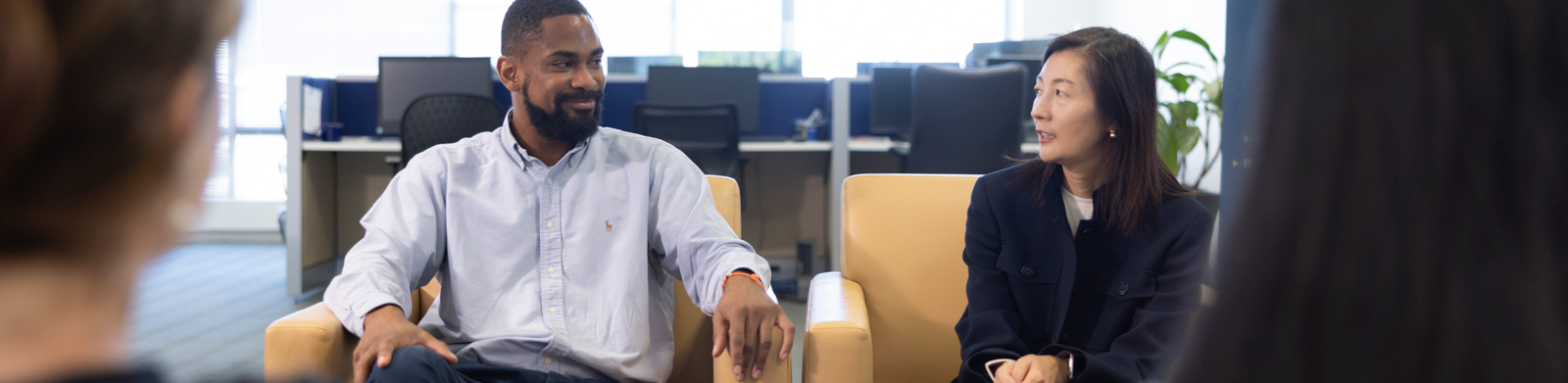 2 people sitting one talking and one who listens and smiles